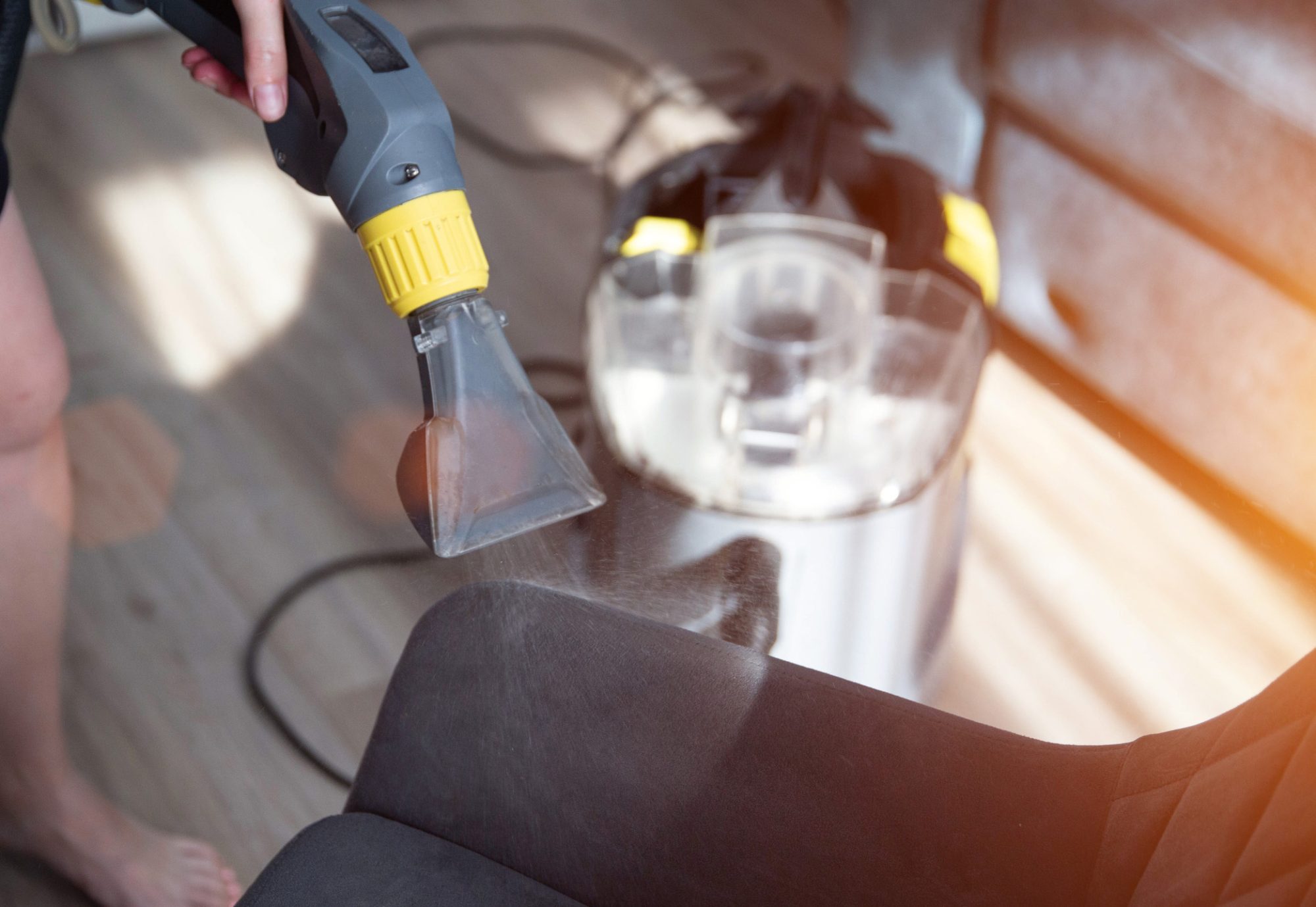Dry cleaning services, washing and cleaning gray fabric chairs with a washing vacuum cleaner, industry.